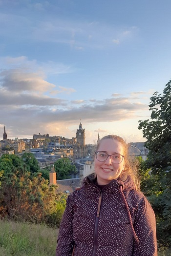 Carina standing in front of a fantastic view of the city center of Edinburgh.